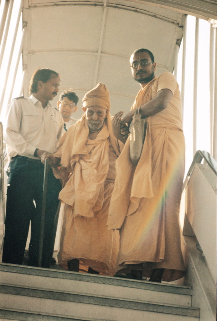 Srila Bhakti Bibudha Bodhayan Goswami Maharaj helping Srila Bhakti Pramod Puri Goswami Thakur. Arriving at Delhi Airport on the way to Vrindavan, 1993